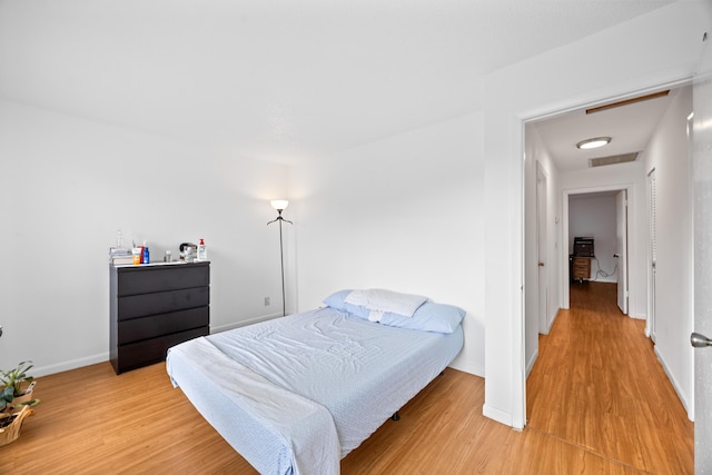 bedroom with visible vents, baseboards, and wood finished floors