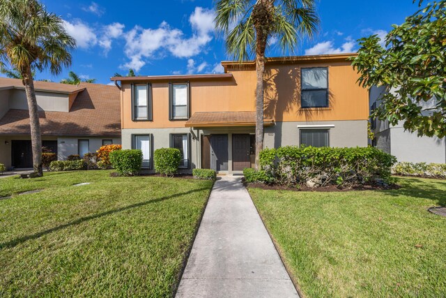 view of front of home with a front lawn and stucco siding