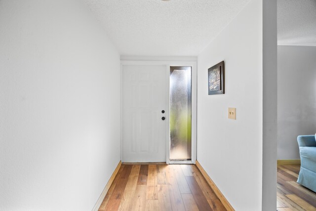 living room with a textured ceiling, dark wood-type flooring, visible vents, baseboards, and stairway