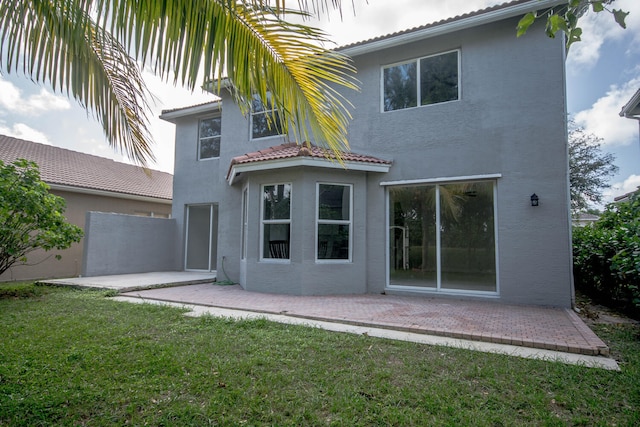 5353 Grand Banks Blvd, Greenacres, FL 33463 - rear view of house featuring a lawn, a patio, stucco siding, and a tiled roof