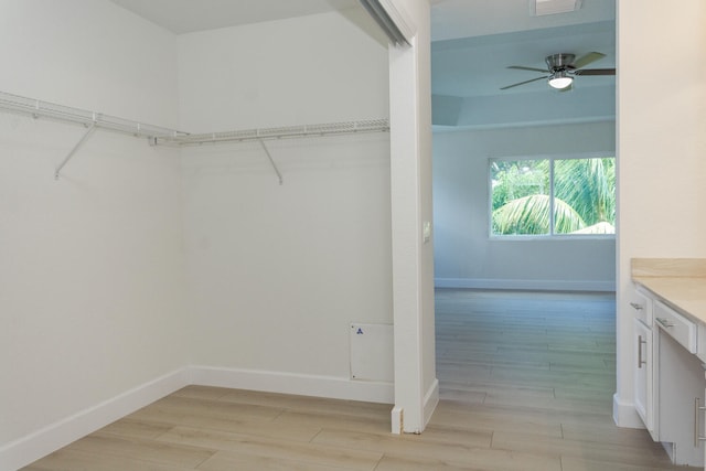 spacious closet with light wood-type flooring and ceiling fan