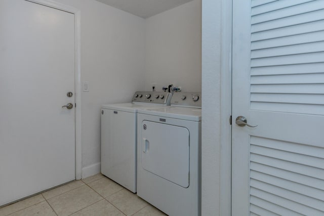 laundry room with washing machine and clothes dryer and light tile patterned flooring