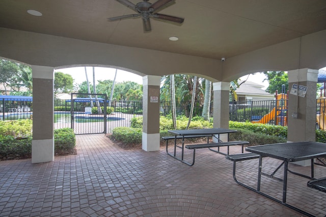 view of patio with ceiling fan, a playground, and a community pool