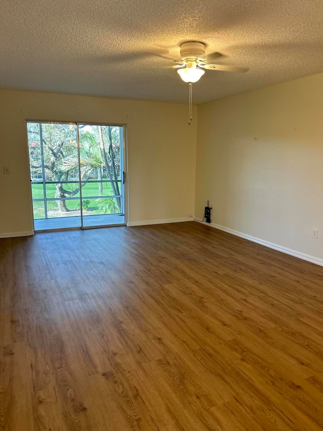 spare room featuring ceiling fan, hardwood / wood-style flooring, and a textured ceiling