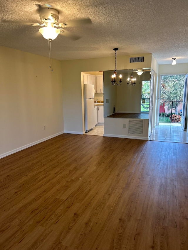 unfurnished living room with ceiling fan, a textured ceiling, and light wood-type flooring