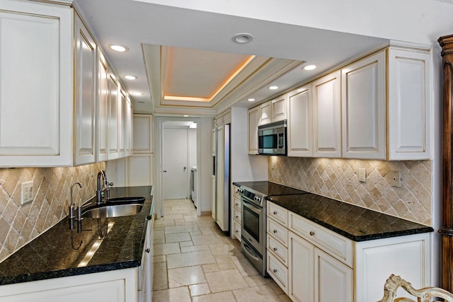 kitchen with appliances with stainless steel finishes, white cabinetry, a raised ceiling, and sink