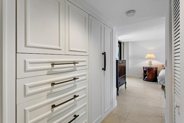 corridor with light tile patterned floors and a textured ceiling