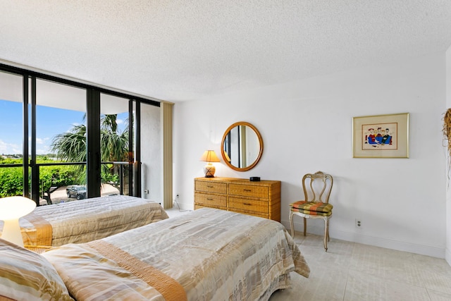 bedroom featuring a textured ceiling, access to outside, and expansive windows