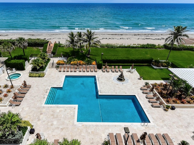 view of swimming pool featuring a water view and a beach view