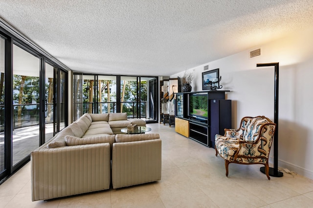 living room with a textured ceiling and a wall of windows