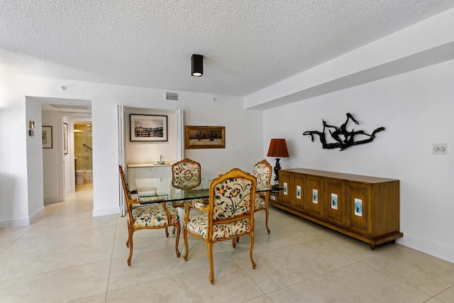 tiled dining space with a textured ceiling