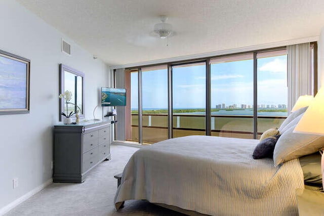 carpeted bedroom featuring access to exterior, a textured ceiling, and ceiling fan