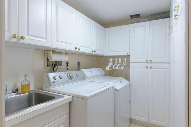 laundry room featuring cabinets, independent washer and dryer, and sink