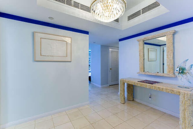 corridor with a notable chandelier and light tile patterned flooring