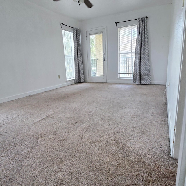 carpeted spare room featuring ceiling fan