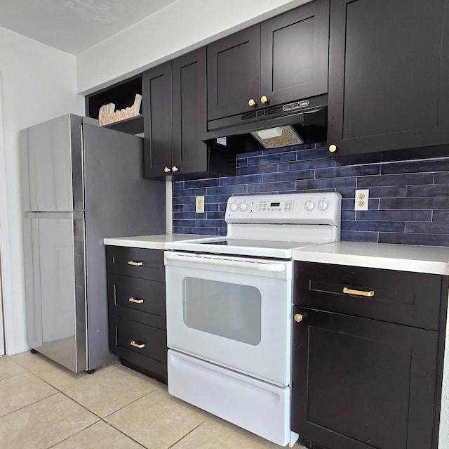 kitchen with electric stove, stainless steel fridge, light tile patterned flooring, and decorative backsplash