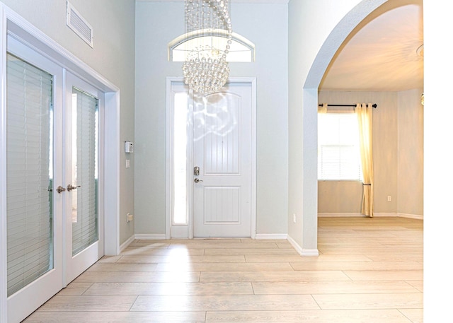 entryway featuring light hardwood / wood-style floors and a notable chandelier