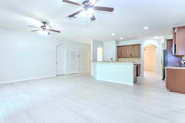 unfurnished living room featuring light hardwood / wood-style flooring and ceiling fan