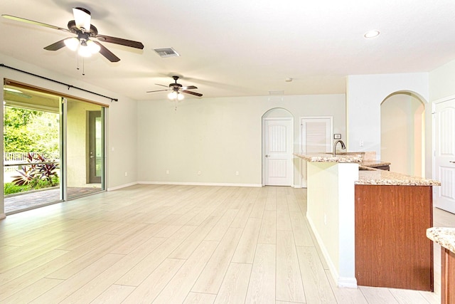 interior space featuring light hardwood / wood-style floors, light stone countertops, and ceiling fan