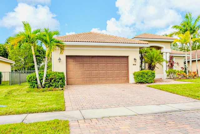 mediterranean / spanish-style house featuring a front yard and a garage