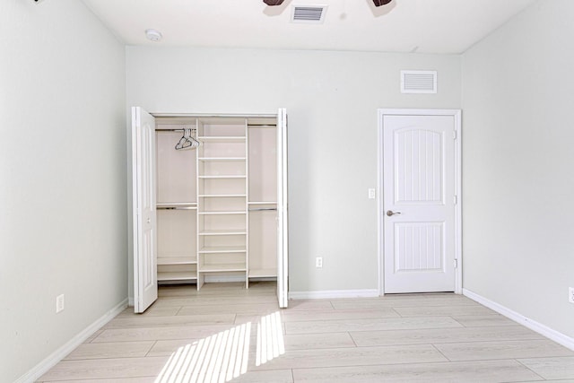 unfurnished bedroom featuring light hardwood / wood-style flooring, a closet, and ceiling fan