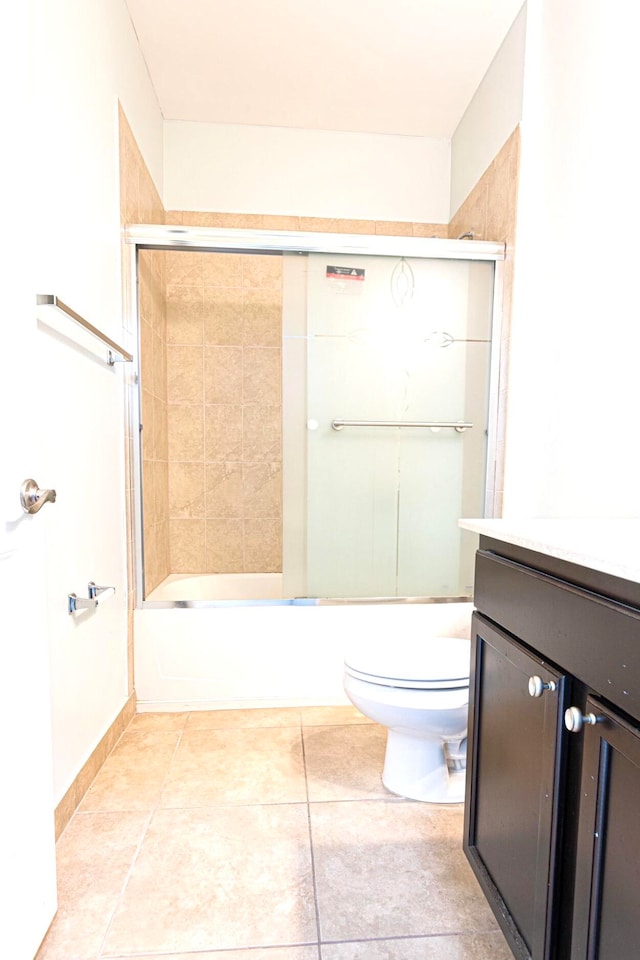 full bathroom featuring vanity, shower / bath combination with glass door, toilet, and tile patterned floors