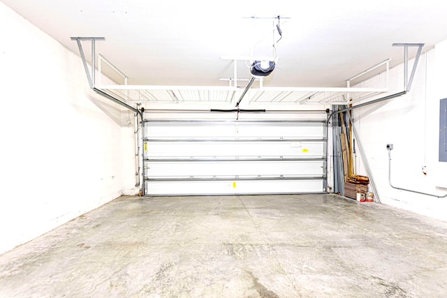 garage with a garage door opener and electric panel