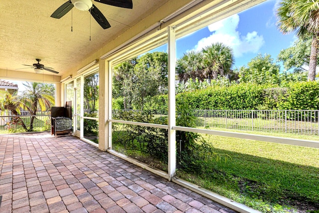 unfurnished sunroom with ceiling fan and a wealth of natural light