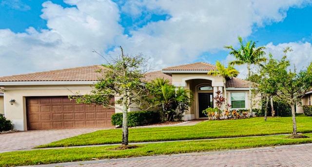 mediterranean / spanish-style house with a front yard and a garage