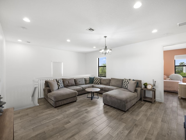 living room with hardwood / wood-style flooring, an inviting chandelier, and plenty of natural light