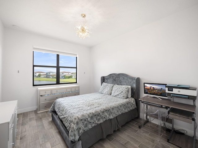 bedroom with a chandelier and hardwood / wood-style floors