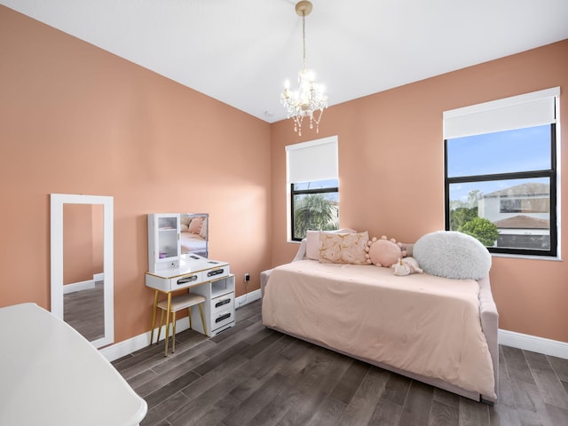 bedroom with dark hardwood / wood-style floors and a chandelier