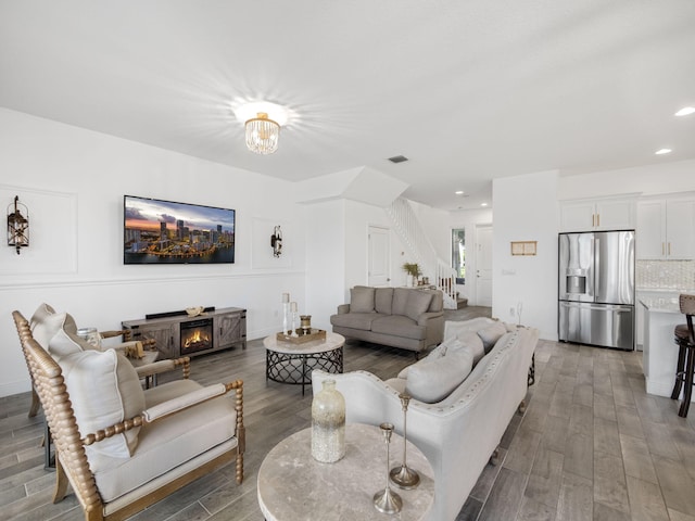 living room with dark wood-type flooring and a fireplace