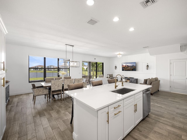 kitchen featuring dishwasher, dark wood-type flooring, a center island with sink, sink, and white cabinetry