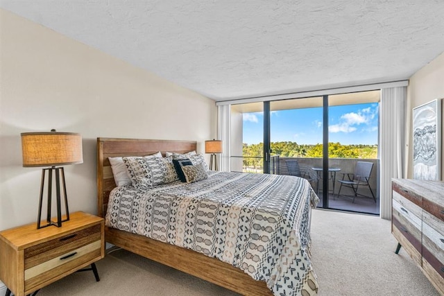 carpeted bedroom featuring access to outside, a textured ceiling, and floor to ceiling windows