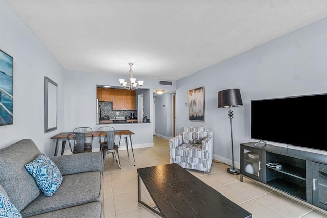 living room featuring a notable chandelier and light tile patterned floors