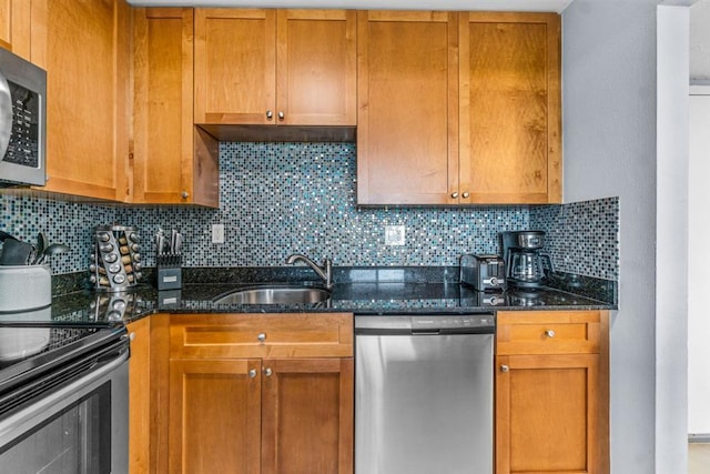 kitchen featuring appliances with stainless steel finishes, dark stone countertops, tasteful backsplash, and sink