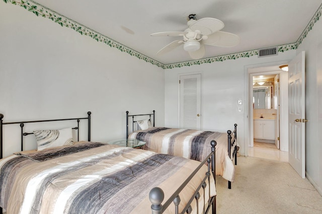 bedroom with light carpet, ensuite bathroom, a closet, and ceiling fan