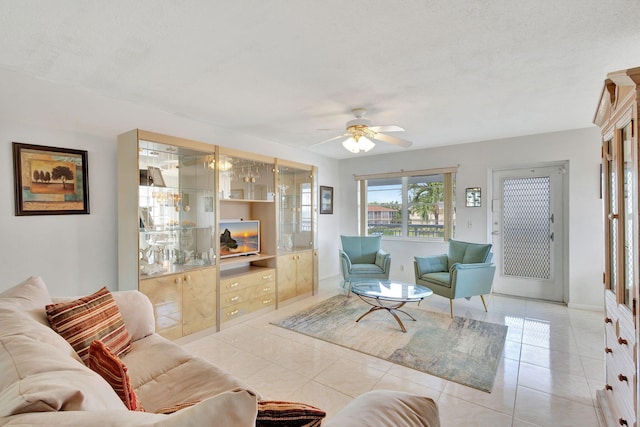 tiled living room featuring ceiling fan and a textured ceiling