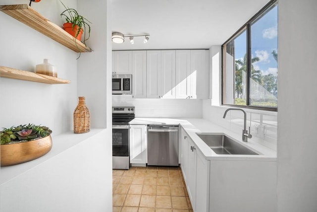 kitchen featuring decorative backsplash, white cabinetry, sink, and stainless steel appliances