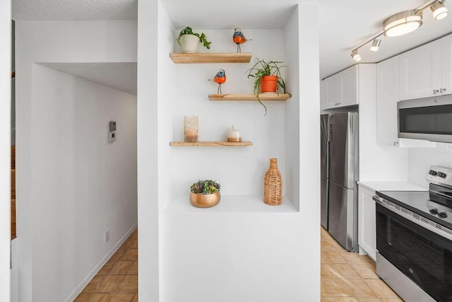 kitchen with light tile patterned floors, white cabinetry, and appliances with stainless steel finishes