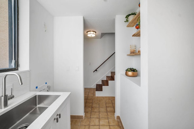 interior space featuring white cabinetry, sink, and light tile patterned floors