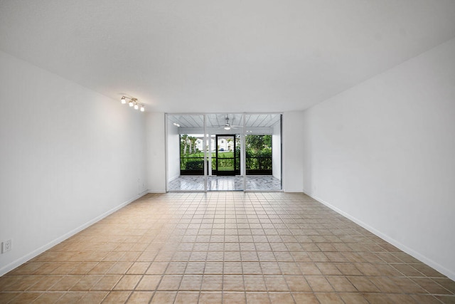 tiled spare room featuring ceiling fan