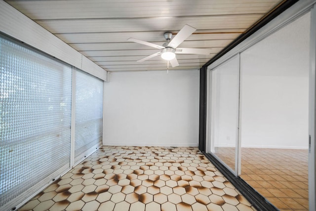 unfurnished sunroom with ceiling fan