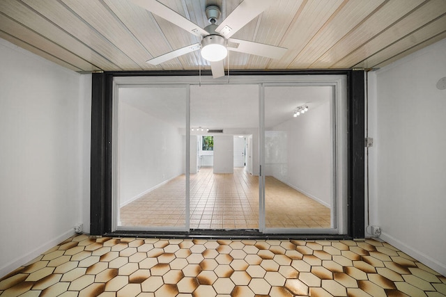 interior space featuring ceiling fan, expansive windows, and wood ceiling