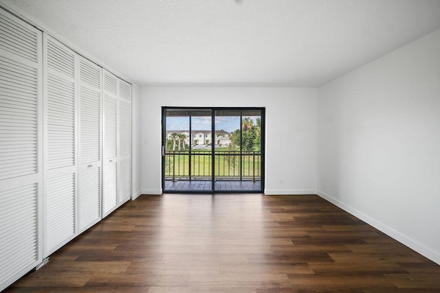 unfurnished bedroom featuring dark hardwood / wood-style flooring, access to outside, and a closet