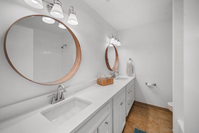 bathroom with tile patterned flooring, vanity, and toilet