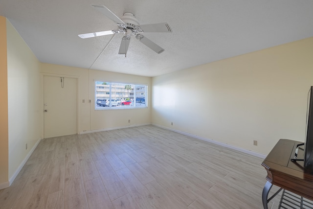 unfurnished room featuring ceiling fan, light hardwood / wood-style floors, and a textured ceiling