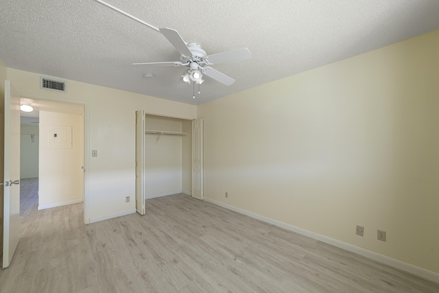 unfurnished bedroom with a textured ceiling, ceiling fan, light hardwood / wood-style flooring, and a closet