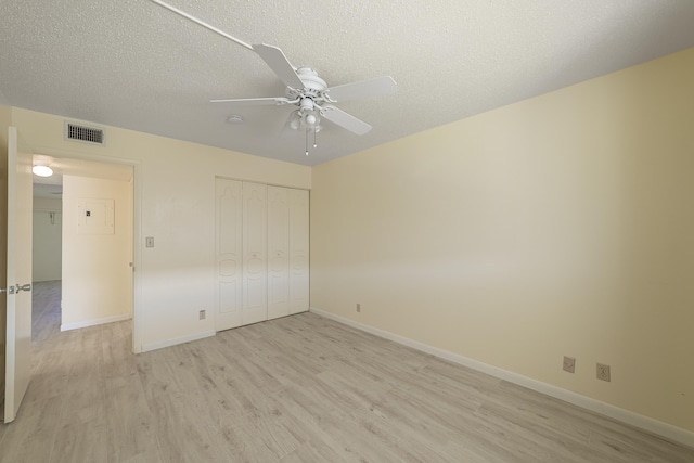 unfurnished bedroom with ceiling fan, a closet, a textured ceiling, and light hardwood / wood-style flooring